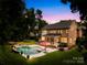 Inviting backyard oasis featuring a swimming pool, covered patio, and ample green space at 7229 Olde Sycamore Dr, Mint Hill, NC 28227
