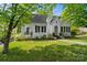 Charming one-story white brick home featuring a manicured lawn, covered porch, and beautifully mature trees at 772 Eden Ter, Rock Hill, SC 29730