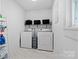 Well-organized laundry room with washer, dryer, shelving, and tiled flooring at 772 Eden Ter, Rock Hill, SC 29730