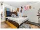 A cozy bedroom with a wooden bed frame, hardwood floors, and various plush toys decorating the wall at 822 Cantwell St, Charlotte, NC 28208