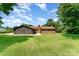 The back of the house features brick and wood siding, with a well-maintained lawn and mature trees at 9410 Mountain Aire Cir, Charlotte, NC 28214