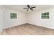 Bright bedroom with two windows and modern ceiling fan, featuring beautiful wood-look flooring at 9410 Mountain Aire Cir, Charlotte, NC 28214