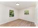 Well-lit bedroom with two windows, wood-look flooring, and a closet at 9410 Mountain Aire Cir, Charlotte, NC 28214