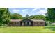 Charming brick ranch-style home with a lush front lawn and mature trees, creating a serene curb appeal at 9410 Mountain Aire Cir, Charlotte, NC 28214