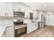 Modern kitchen featuring white cabinets, stainless steel appliances, and a stylish subway tile backsplash at 9410 Mountain Aire Cir, Charlotte, NC 28214