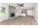 Inviting living room featuring a brick fireplace, sleek ceiling fan, and an open layout leading to the modern kitchen at 9410 Mountain Aire Cir, Charlotte, NC 28214