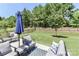 Scenic backyard featuring lush greenery and patio with comfortable seating under a blue umbrella at 9541 Festival Way, Charlotte, NC 28215