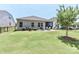 Large backyard featuring well-kept lawn, mature trees, and patio with comfortable outdoor furniture at 9541 Festival Way, Charlotte, NC 28215