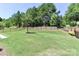 Expansive, green backyard featuring an iron fence, landscaping, and mature trees offering privacy and a serene atmosphere at 9541 Festival Way, Charlotte, NC 28215