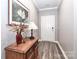 Entryway features a wooden accent table, a beautiful flower arrangement, and pristine hardwood floors at 9541 Festival Way, Charlotte, NC 28215