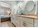 Bright bathroom features a double vanity with granite countertops, round mirrors, and neutral tile floor at 1007 Southwest Dr, Davidson, NC 28036