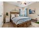This bedroom features a wood bed frame, neutral walls, and windows with bright blue curtains at 1007 Southwest Dr, Davidson, NC 28036