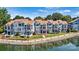 View of blue townhome showcasing a waterfront with well-manicured landscaping at 1007 Southwest Dr, Davidson, NC 28036