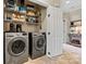 Functional laundry room with modern washer and dryer units, storage shelves, and access to outside at 1007 Southwest Dr, Davidson, NC 28036