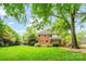 Large backyard with well-maintained lawn and mature trees creating a serene outdoor space at 10918 Megwood Dr, Charlotte, NC 28277