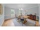 Bright dining room featuring hardwood floors, stylish light fixture, and wooden table at 10918 Megwood Dr, Charlotte, NC 28277