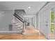 Inviting foyer with hardwood floors, staircase, and view into dining area at 10918 Megwood Dr, Charlotte, NC 28277