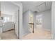 Hallway leading to a bedroom and bathroom with stairs and linen closet at 10918 Megwood Dr, Charlotte, NC 28277
