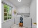 Bright laundry room featuring washer, dryer, storage cabinets, and a window at 10918 Megwood Dr, Charlotte, NC 28277