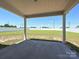 A covered concrete patio offers an excellent view of the expansive fenced backyard, perfect for outdoor relaxation at 11507 Valley Oak Ln, Stanfield, NC 28163