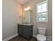 Stylish half bathroom features granite countertops, gray cabinetry, modern fixtures, and a bright window at 11507 Valley Oak Ln, Stanfield, NC 28163