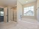 Well-appointed bathroom with a soaking tub, a glass-enclosed shower, and a bright window at 11507 Valley Oak Ln, Stanfield, NC 28163