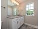 Bright bathroom featuring a granite-topped double vanity with white cabinets, a large mirror, and modern fixtures at 11507 Valley Oak Ln, Stanfield, NC 28163