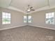 Spacious bedroom with tray ceiling, ceiling fan, neutral carpet, and large windows providing ample natural light at 11507 Valley Oak Ln, Stanfield, NC 28163