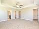 Large bedroom showcasing tray ceiling, fan, neutral carpet and entrances to a walk-in closet and bathroom at 11507 Valley Oak Ln, Stanfield, NC 28163