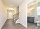 Inviting entryway with beautiful wood-look floors, staircase, and a glimpse of a conveniently located half bathroom at 11507 Valley Oak Ln, Stanfield, NC 28163