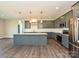 Open kitchen with stainless appliances, granite island, and pendant lights, perfect for modern living at 11507 Valley Oak Ln, Stanfield, NC 28163
