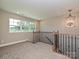 Well-lit upper landing featuring plush carpeting, elegant railing, and a modern chandelier at 11507 Valley Oak Ln, Stanfield, NC 28163