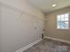 A bright laundry room features sleek vinyl flooring and a convenient wire storage rack above washer/dryer hookups at 11507 Valley Oak Ln, Stanfield, NC 28163