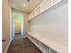 The mudroom features custom built-in shelving and a bench for organized storage, located off of a hallway at 11507 Valley Oak Ln, Stanfield, NC 28163