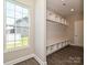 A well-lit mudroom boasts custom built-in shelving, bench, and cubbies by a window for organized storage at 11507 Valley Oak Ln, Stanfield, NC 28163