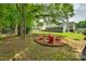 Expansive backyard featuring mature trees, a fire pit area, a hammock, and a swing at 11615 Chadburn Ln, Charlotte, NC 28215