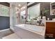 Bright bathroom with a soaking tub, separate glass shower, and plants offers a relaxing and stylish space at 11615 Chadburn Ln, Charlotte, NC 28215