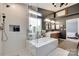 Luxurious bathroom featuring a soaking tub, glass shower, dual vanities, and sleek, modern fixtures at 11615 Chadburn Ln, Charlotte, NC 28215