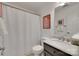 Well-lit bathroom features a framed vanity mirror, tiled floors, and a shower with a white shower curtain at 11615 Chadburn Ln, Charlotte, NC 28215
