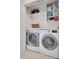 Functional laundry room with modern washer and dryer, counter space, and shelving for storage at 11615 Chadburn Ln, Charlotte, NC 28215