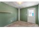 Unfinished basement with a door, shelving, and fresh green paint, offering potential for customization at 1204 May Apple Dr, Matthews, NC 28104