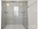 Bathroom featuring a bright glass enclosed shower with a window and built-in shelving at 1204 May Apple Dr, Matthews, NC 28104