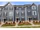 New three-story townhomes with blue siding, brown shutters, and manicured landscaping at 1204 May Apple Dr, Matthews, NC 28104