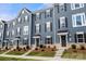 Charming townhome featuring a landscaped front yard and a welcoming entrance, showcasing modern design and curb appeal at 1204 May Apple Dr, Matthews, NC 28104
