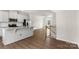 Bright, open kitchen showcasing white cabinetry, stainless appliances and a granite island with adjacent staircase at 1204 May Apple Dr, Matthews, NC 28104