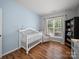 Light-filled Bedroom features wood floors, crib, and seating area, perfect for new Gathering at 1228 Rising Oak Dr, Charlotte, NC 28206