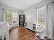 Bright Bedroom with wood floors, a crib, dresser, and comfortable seating area at 1228 Rising Oak Dr, Charlotte, NC 28206