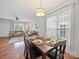Open dining area with hardwood floors and modern lighting seamlessly connects the kitchen and living spaces at 1228 Rising Oak Dr, Charlotte, NC 28206