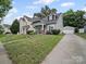 Charming home with a detached garage, lush green lawn and mature trees at 1228 Rising Oak Dr, Charlotte, NC 28206