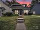 Charming home featuring manicured lawn and welcoming front porch with inviting chairs and decor at 1228 Rising Oak Dr, Charlotte, NC 28206